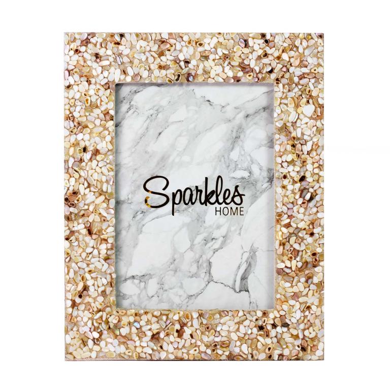 A rectangular picture frame with a shell and bead design in beige cream and soft pink tones surrounding a marble-patterned inner section.