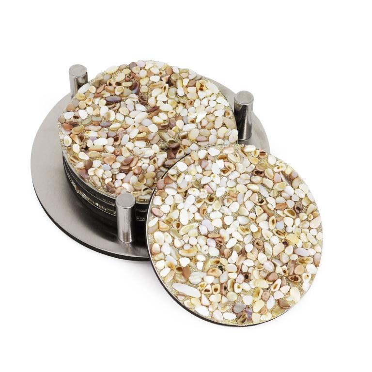 Round coasters made of mixed small shells in beige cream and light brown with a stainless steel base and foam backing.