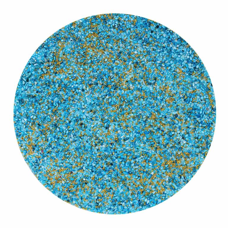 Round placemat in aqua with textured surface featuring small blue and gold embellishments resembling sand and shells.