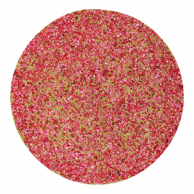 Round placemat with a textured surface featuring pink and coral pieces with gold accents resembling crushed shells or coral.