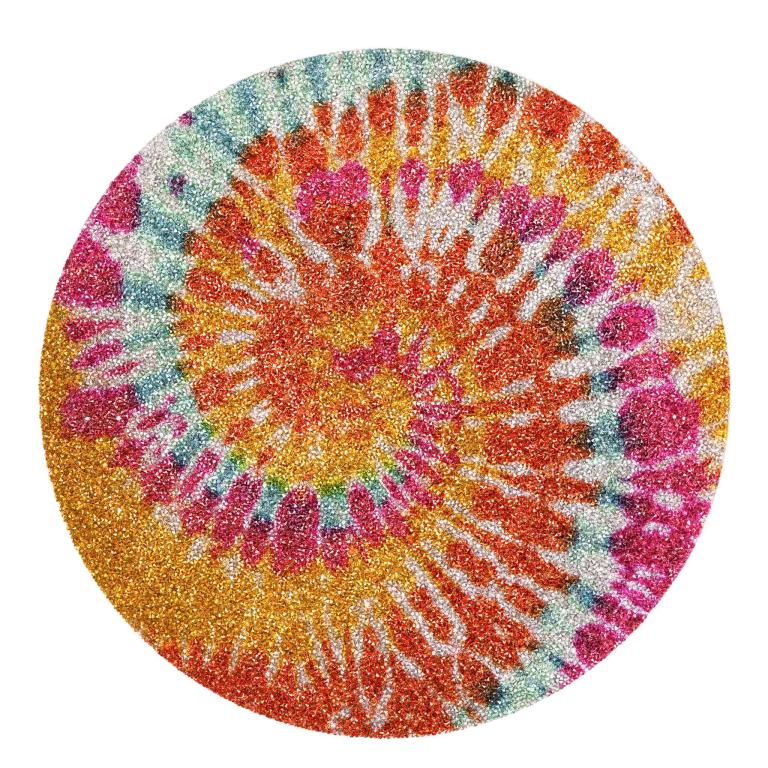 Round placemat featuring a vibrant tie-dye pattern in orange red green and purple with a glittery texture and rhinestone embellishments.