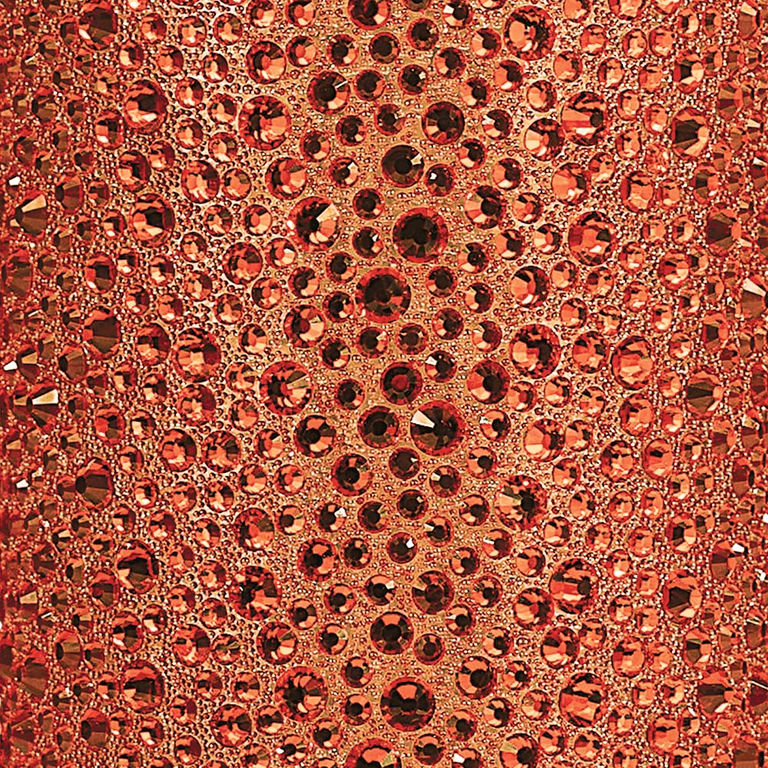 Orange fabric adorned with various sizes of round faceted rhinestones in shades of orange and amber.