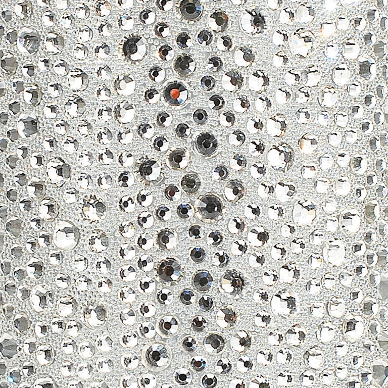 A textured silver surface adorned with various sizes of clear and black rhinestones arranged closely together.