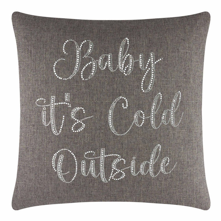 Square brown pillow with glass rhinestones spelling "Baby it's Cold Outside" on a textured fabric surface.