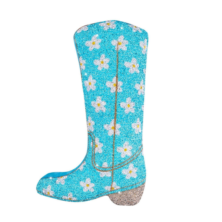 Blue boot-shaped pillow covered in glitter with white flowers and yellow centers featuring a textured soft surface and a shiny base.