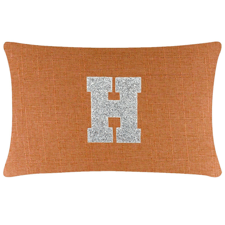 Rectangular orange pillow with a textured fabric and a silver rhinestone letter "H" in the center.