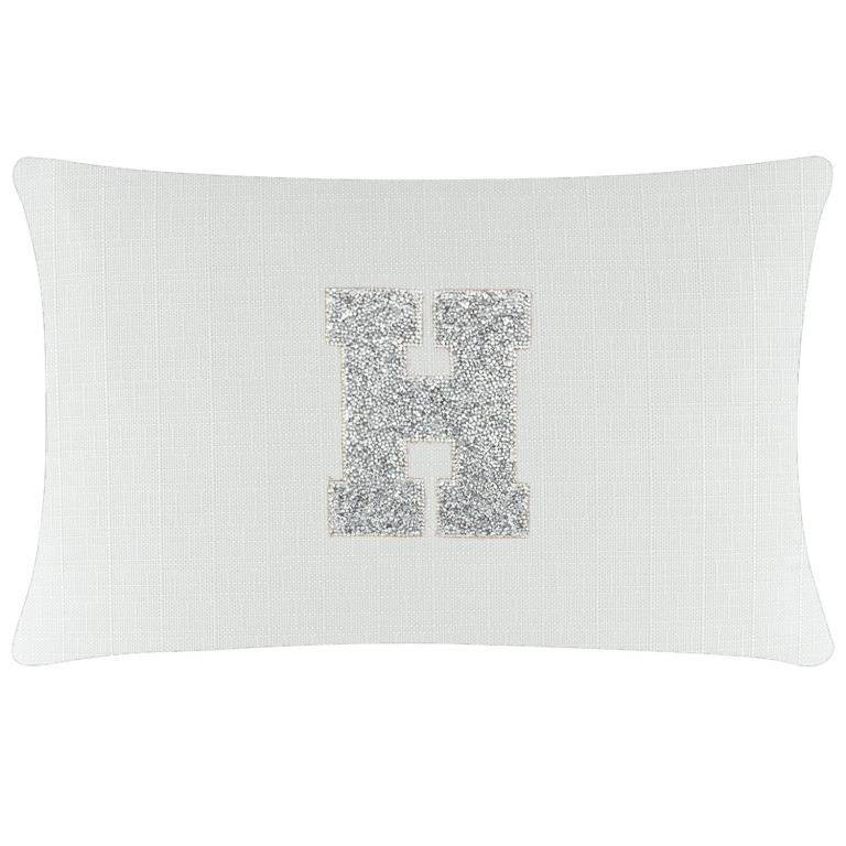White rectangular pillow with a textured surface featuring a silver rhinestone monogram "H" in the center.