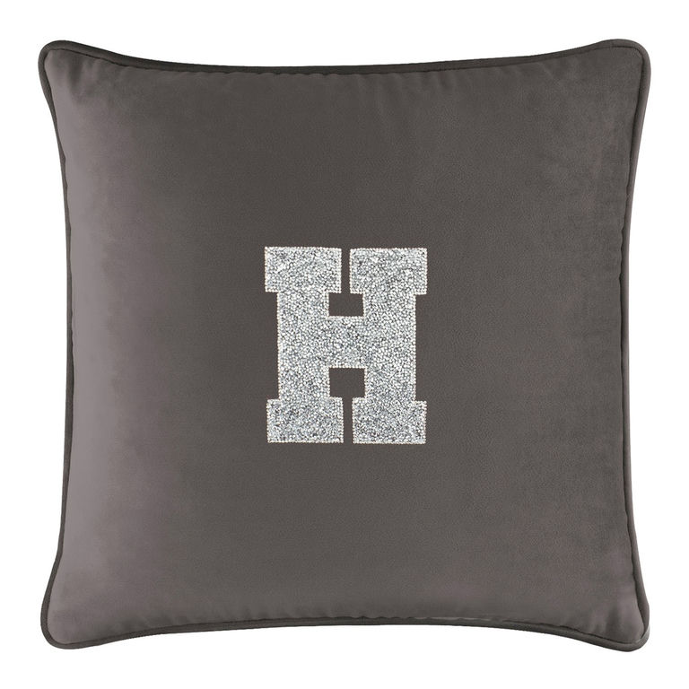 Charcoal velvet pillow with a rhinestone-embellished letter "H" in the center and a contrasting trim around the edges.