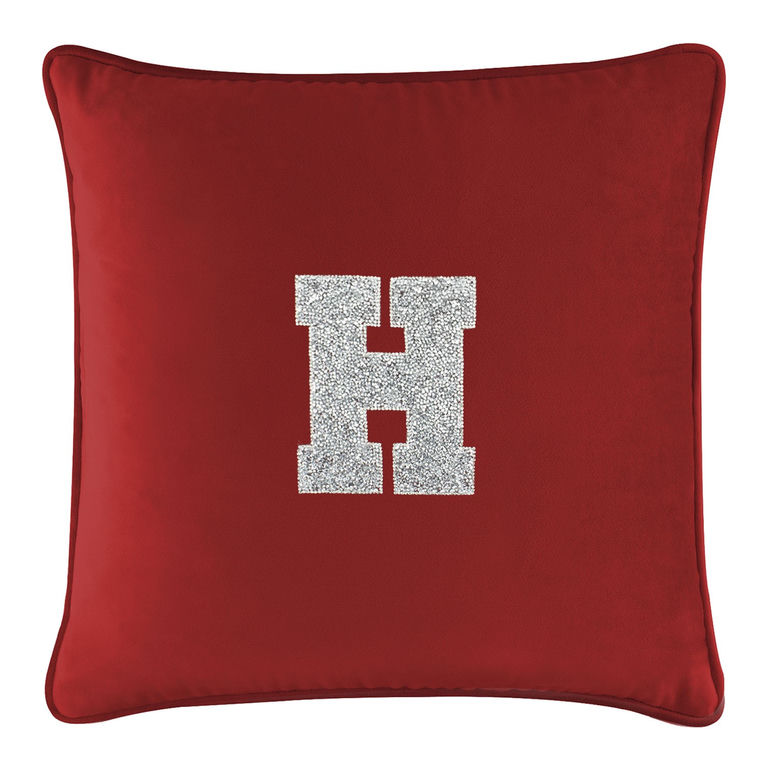 Red velvet pillow featuring a large silver rhinestone monogram "H" in the center with a soft plush texture.