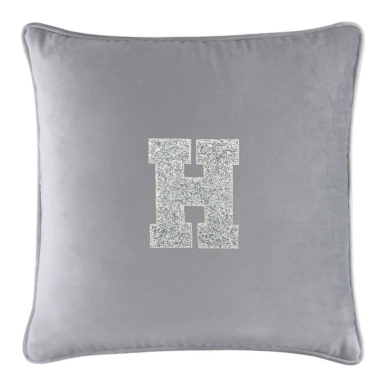 Square silver velvet pillow featuring a glittering rhinestone letter "H" in the center.