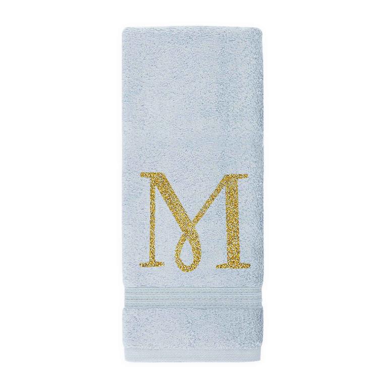 Aqua cotton terry hand towel with a gold glitter monogram "M" and a textured border at the bottom.