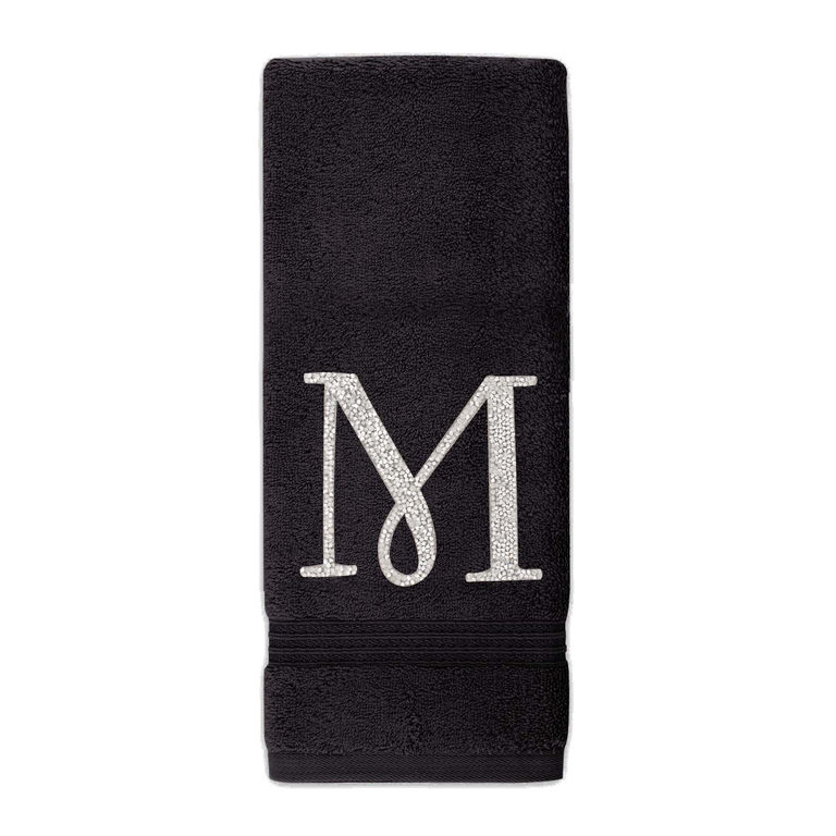 Black cotton terry hand towel with a silver rhinestone monogram "M" and a textured border at the bottom.