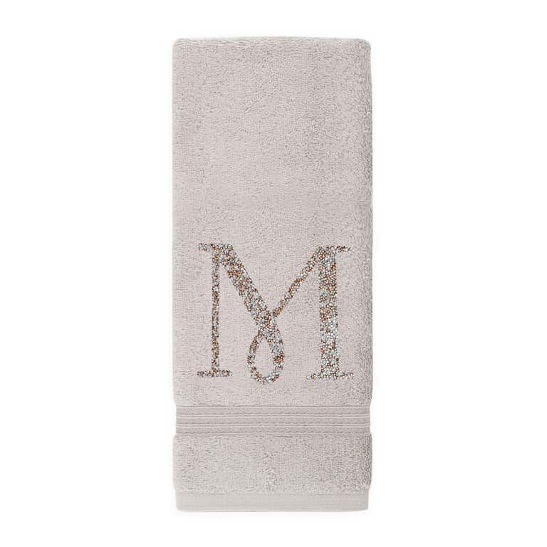 Gray plush cotton terry hand towel with a rhinestone monogram "M" and two horizontal stripes at the bottom.
