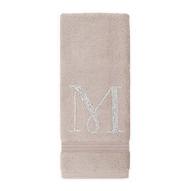 Taupe cotton terry hand towel with a rhinestone monogram "M" and a textured band at the bottom.
