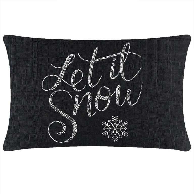 Black rectangular pillow featuring "Let it Snow" in glass rhinestones and a snowflake design on a textured fabric surface.