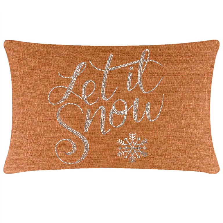 Rectangular orange pillow with a textured fabric featuring silver rhinestone lettering and a snowflake design.