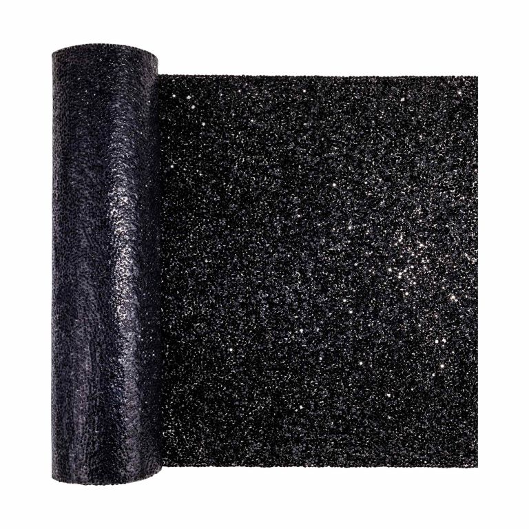 Black table runner with a textured surface embellished with sparkling rhinestones in various colors rolled at the ends.