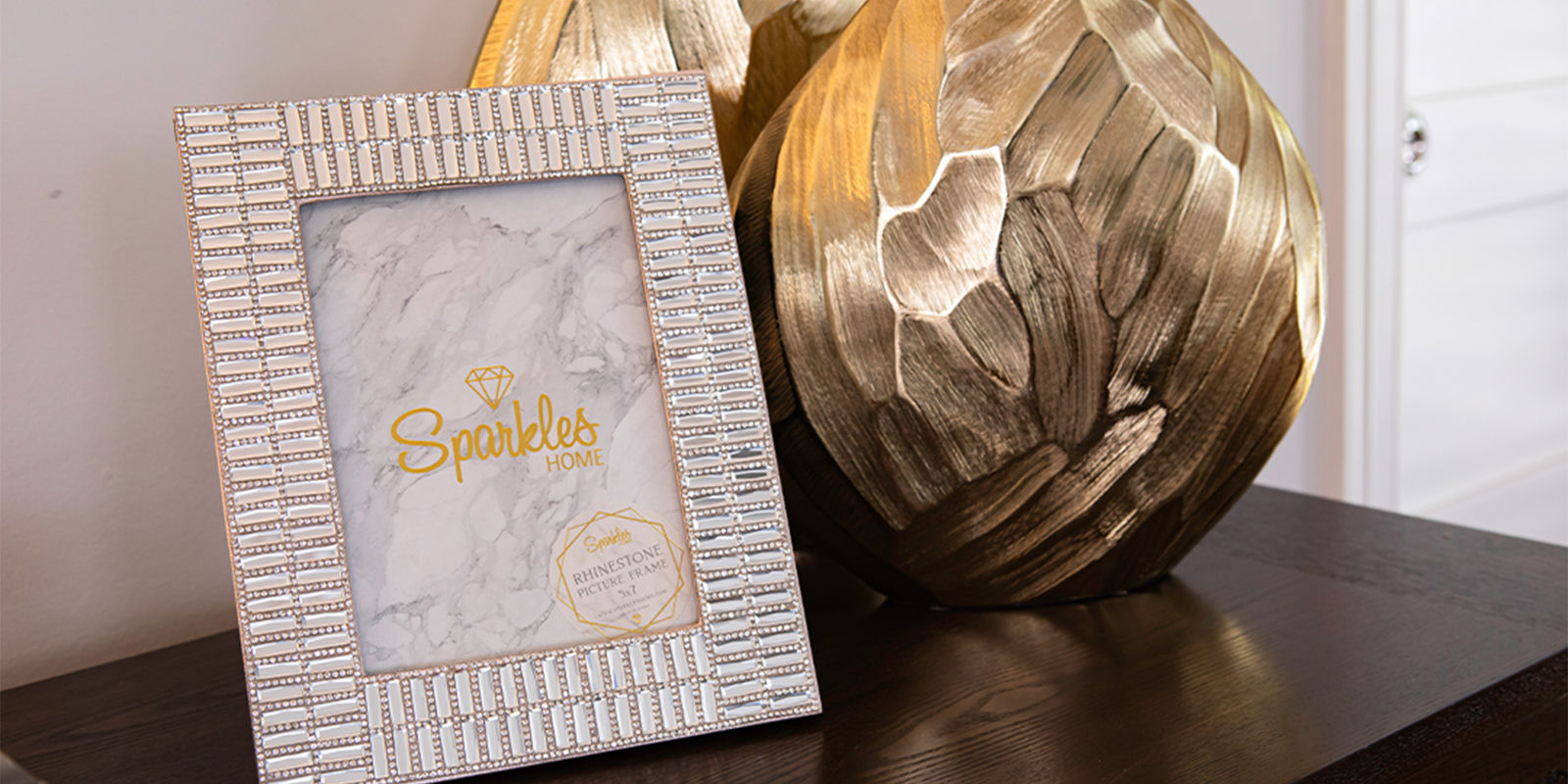 Jeweled&amp;&#x23;x20&#x3B;photo&amp;&#x23;x20&#x3B;frame&amp;&#x23;x20&#x3B;beside&amp;&#x23;x20&#x3B;a&amp;&#x23;x20&#x3B;textured&amp;&#x23;x20&#x3B;gold&amp;&#x23;x20&#x3B;vase&amp;&#x23;x20&#x3B;on&amp;&#x23;x20&#x3B;a&amp;&#x23;x20&#x3B;dark&amp;&#x23;x20&#x3B;tabletop