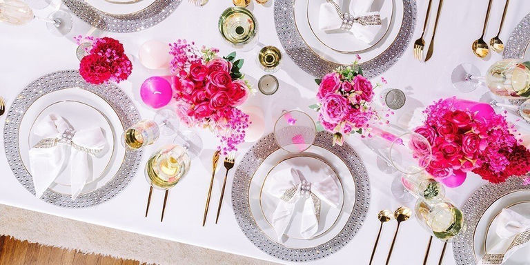 mesa de verano glamorosa con manteles individuales de pedrería, cubiertos dorados y centro floral vibrante