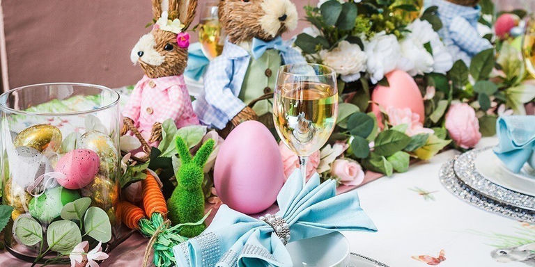 décor de table de Pâques avec sous-assiettes métalliques, ronds de serviette à strass, guirlande florale et nappe imprimée de lapins