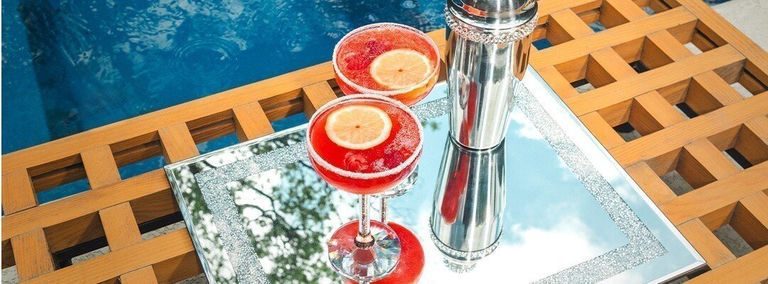 installation de cocktails luxueuse au bord de la piscine avec plateau en strass, shaker scintillant et boissons aux fruits rouges