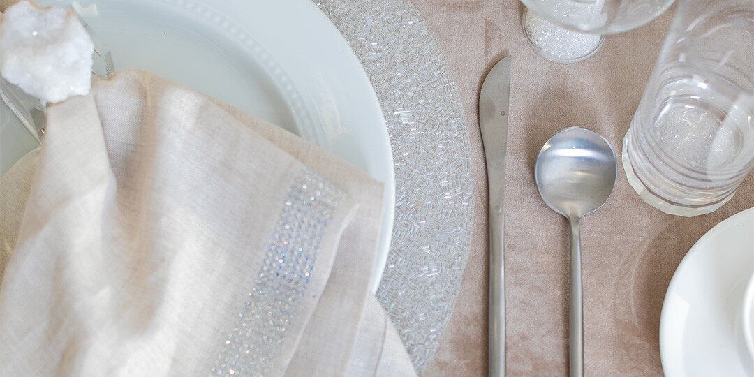 Elegante&amp;&#x23;x20&#x3B;mesa&amp;&#x23;x20&#x3B;con&amp;&#x23;x20&#x3B;plato&amp;&#x23;x20&#x3B;blanco&amp;&#x23;x20&#x3B;sobre&amp;&#x23;x20&#x3B;mantel&amp;&#x23;x20&#x3B;individual&amp;&#x23;x20&#x3B;transparente&amp;&#x23;x20&#x3B;con&amp;&#x23;x20&#x3B;cuentas,&amp;&#x23;x20&#x3B;servilleta&amp;&#x23;x20&#x3B;blanca,&amp;&#x23;x20&#x3B;cubiertos&amp;&#x23;x20&#x3B;pulidos&amp;&#x23;x20&#x3B;y&amp;&#x23;x20&#x3B;cristaler&amp;&#x23;xED&#x3B;a&amp;&#x23;x20&#x3B;transparente&amp;&#x23;x20&#x3B;dispuestos&amp;&#x23;x20&#x3B;sobre&amp;&#x23;x20&#x3B;una&amp;&#x23;x20&#x3B;superficie&amp;&#x23;x20&#x3B;beige&amp;&#x23;x20&#x3B;texturizada&amp;&#x23;x20&#x3B;neutral.