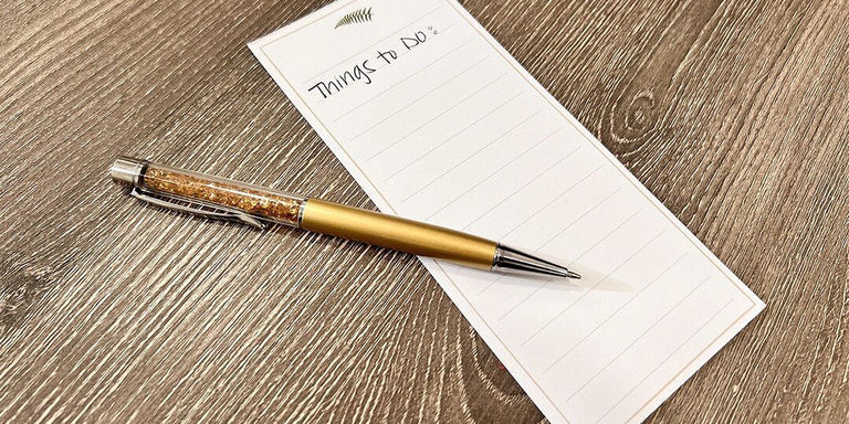Gold ballpoint pen with rhinestone-embellished barrel lying across a