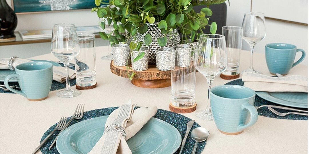 Neutral&amp;&#x23;x20&#x3B;tablescape&amp;&#x23;x20&#x3B;with&amp;&#x23;x20&#x3B;greenery&amp;&#x23;x20&#x3B;centerpiece,&amp;&#x23;x20&#x3B;crystal&amp;&#x23;x20&#x3B;votives,&amp;&#x23;x20&#x3B;and&amp;&#x23;x20&#x3B;blue&amp;&#x23;x20&#x3B;ceramic&amp;&#x23;x20&#x3B;dinnerware