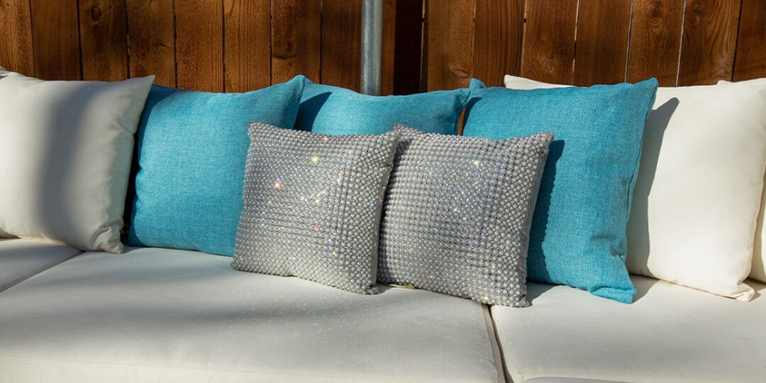 outdoor&amp;&#x23;x20&#x3B;sofa&amp;&#x23;x20&#x3B;with&amp;&#x23;x20&#x3B;glam&amp;&#x23;x20&#x3B;rhinestone&amp;&#x23;x20&#x3B;pillows&amp;&#x23;x20&#x3B;and&amp;&#x23;x20&#x3B;turquoise&amp;&#x23;x20&#x3B;cushions&amp;&#x23;x20&#x3B;on&amp;&#x23;x20&#x3B;wood-paneled&amp;&#x23;x20&#x3B;patio