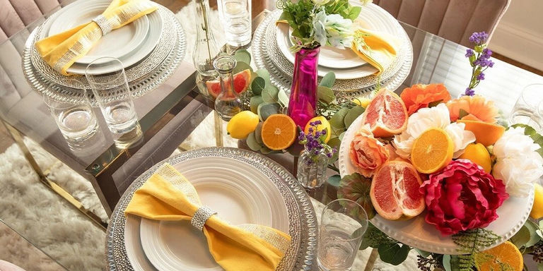 Bright floral fruit centerpiece with vibrant citrus and peonies on spring glam table setting