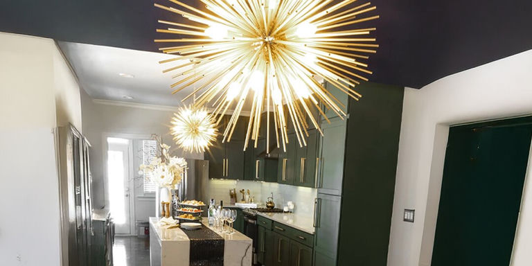 gold starburst chandeliers above glam kitchen island