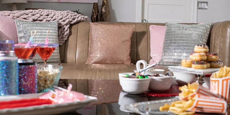 cozy sofa setup with glam pillows, pink accents, and movie snacks for Galentine Day rhinestone decorations