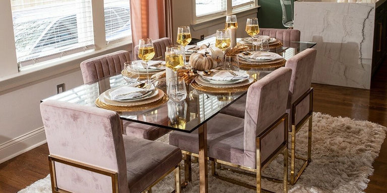 glam glass dining table set with pink velvet chairs and gold trim