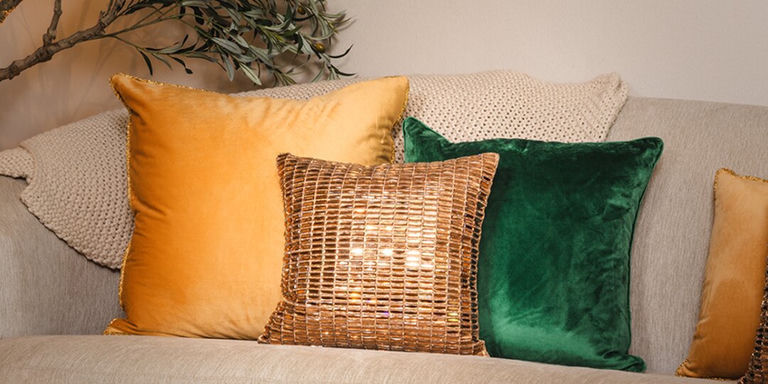 neutral glam fall living room with gold, green, and bronze rhinestone pillows