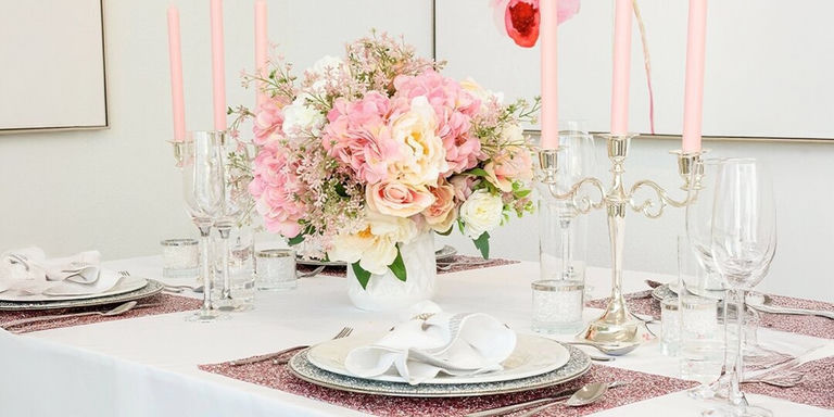 Pink and cream floral centerpiece with pink taper candles and silver table decor