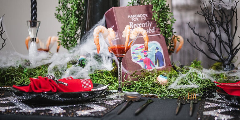 Beetlejuice-inspired Halloween glam tablescape with black and white rhinestone placemats and red napkins