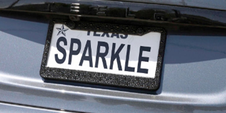 marco de placa de matrícula de pedrería en auto gris con placa SPARKLE de Texas