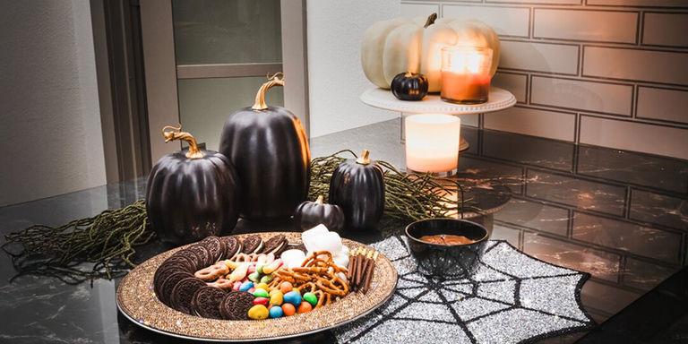tablero de golosinas de Halloween con estilo glamoroso en un plato cargador de pedrería con dulces coloridos