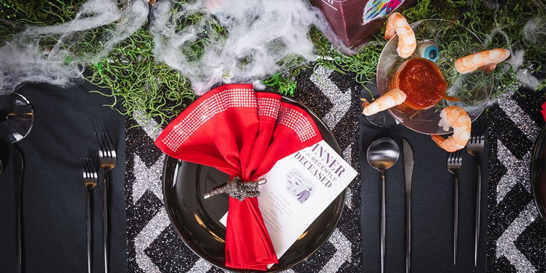 overhead view of spooky Halloween tablescape with rhinestone decor, haunted centerpiece, and spooky cocktails