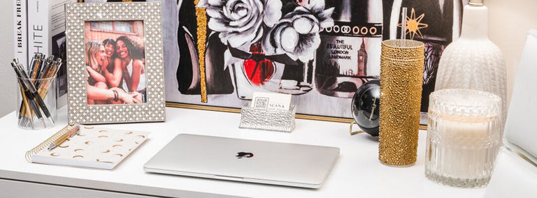 accesorios de oficina glamorosos en dorado y plateado en escritorio blanco con computadora portátil