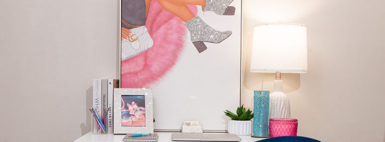 configuración de oficina en casa con accesorios glamorosos plateados y arte de brillo enmarcado