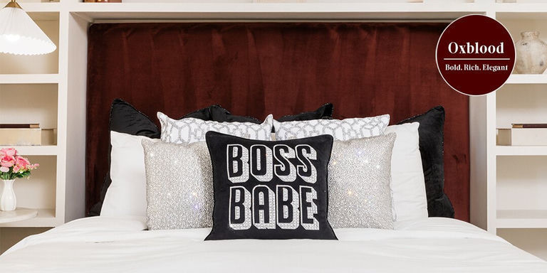 cabecero de terciopelo oxblood con cojines decorativos de estrás y decoración glamorosa en un rincón de cama empotrada