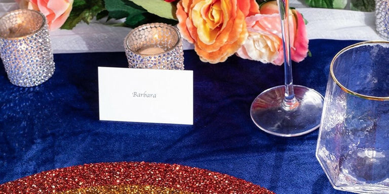 Glamorous navy and gold velvet tablescape with rhinestone candle holders and orange florals
