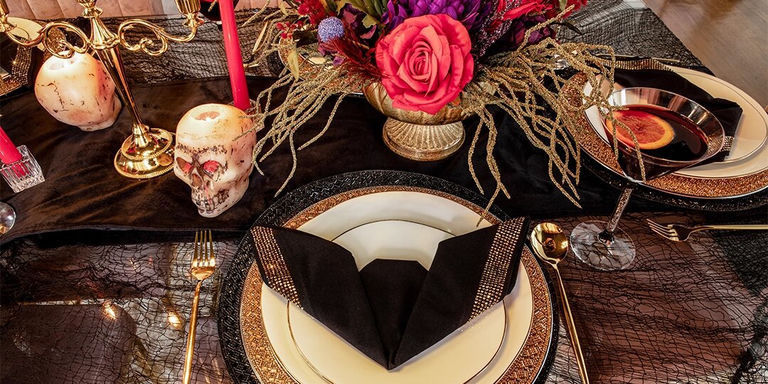 black and gold Halloween tablescape with dramatic florals and candlelight